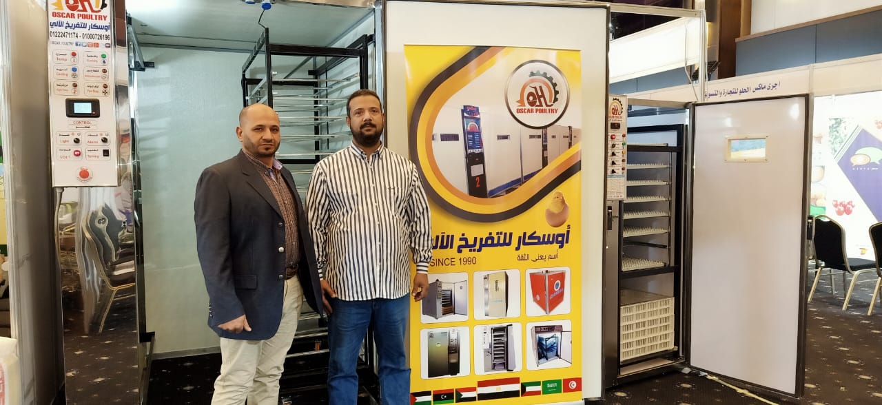 Oscar team members standing inside the booth beside hatching equipment